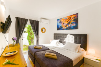 Chambre d'amis avec deux lits simples et accès direct au jardin de Casa Feliz Nerja