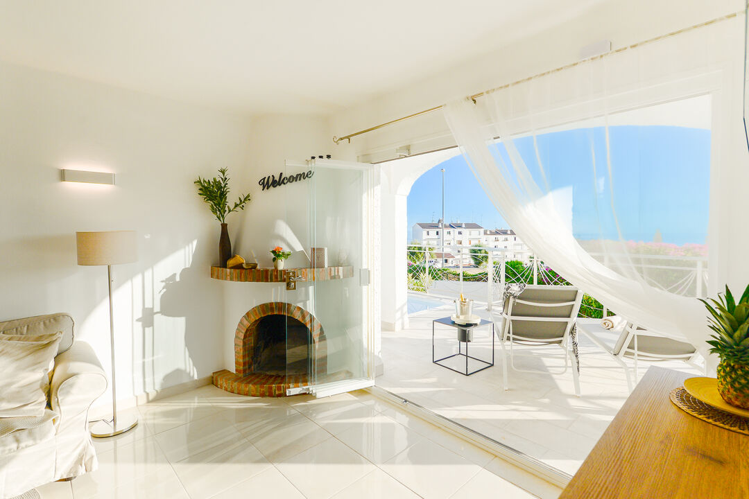Salon avec cheminée et vue sur la piscine